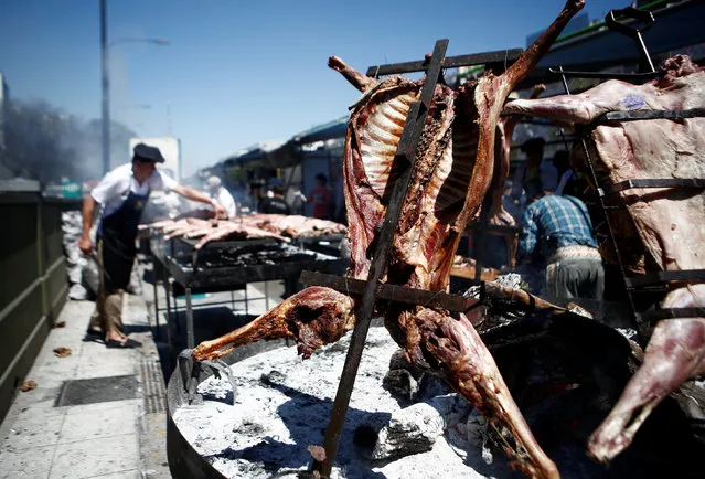 A man grills meat during a barbecue contest in Buenos Aires, Argentina, October 9, 2016. (Photo by Agustin Marcarian/Reuters)