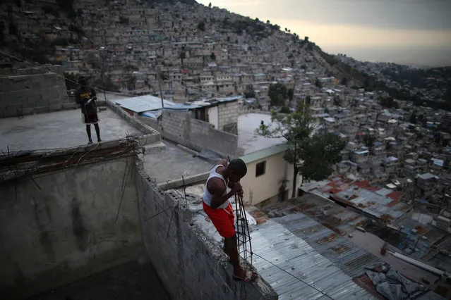 A boy walks on a wall in a slum of Port-au-Prince, Haiti on February 6, 2018. (Photo by Andres Martinez Casares/Reuters)