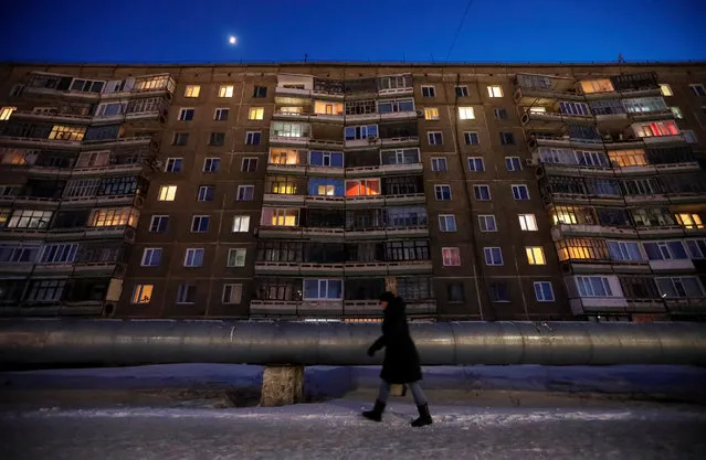 A woman walks past an apartment in the town of Aksu, north-eastern Kazakhstan, February 22, 2018. (Photo by Shamil Zhumatov/Reuters)