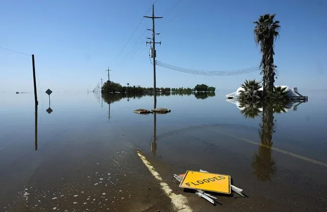 Floodwaters cover a street in the reemerging Tulare Lake, in California's Central Valley, on April 14, 2023 in Corcoran, California. Tulare Lake, once the largest body of freshwater west of the Mississippi River, disappeared when waters were diverted by agricultural interests to irrigate crops in the late 19th and early 20th century. Recent atmospheric river storm events caused significant flooding in the lakebed area with thousands of acres of farmland flooded. The impending Sierra Nevada mountains snowmelt, with snowpack levels around historic highs, could expand the lake size to 200 square miles, threatening farming communities and billions in losses. (Photo by Mario Tama/Getty Images)