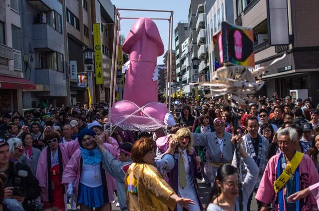 A large pink phallic-shaped “Mikoshi” is paraded through the streets during Kanamara Matsuri (Festival of the Steel Phallus) on April 1, 2018 in Kawasaki, Japan. The Kanamara Festival is held annually on the first Sunday of April. The pen*s is the central theme of the festival, focused at the local pen*s-venerating shrine which was once frequented by prostitutes who came to pray for business prosperity and protection against sexually transmitted diseases. Today the festival has become a popular tourist attraction and is used to raise money for HIV awareness and research. (Photo by Carl Court/Getty Images)