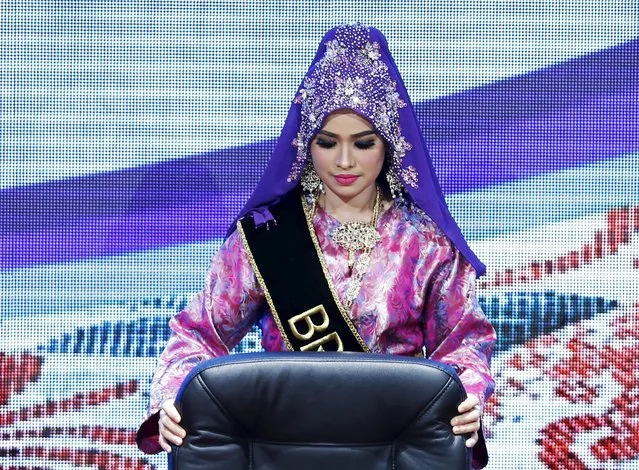 A hostess pulls out a chair during a Signing Ceremony Against Trafficking in Persons at the 27th Association of Southeast Asian Nations (ASEAN) summit in Kuala Lumpur, Malaysia, November 21, 2015. (Photo by Olivia Harris/Reuters)