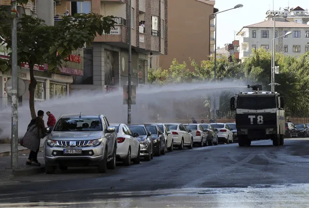 Police use water cannons against pro-Kurdish Peoples's Democratic Party members as they protest the detention of Gultan Kisanak, Diyarbakir Mayor, and co-mayor Firat Anli, in Diyarbakir, Turkey, Wednesday, October 26, 2016. Turkish police on Wednesday used tear gas and water cannons to disperse hundreds of demonstrators protesting the detentions of two leading politicians in the largest city in the country's mainly-Kurdish southeast. About a thousand people gathered outside the Diyarbakir municipality to demand the release of Kisanak and Anli, who were taken into custody late Tuesday as part of a terrorism investigation. (Photo by Mahmut Bozarslan/AP Photo)