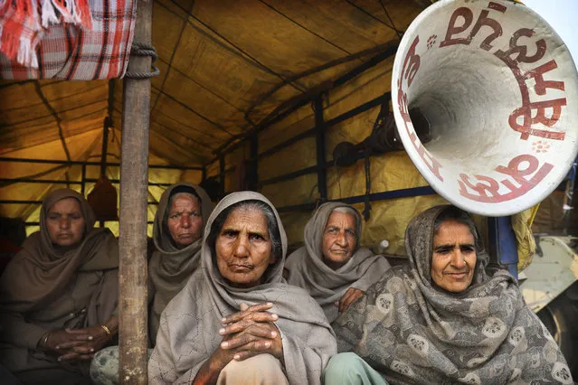 Elderly women farmers sit at the back of a trailer as they participate in a protest against new farm laws at the Delhi-Haryana state border, on the outskirts of New Delhi, India, Sunday, December 27, 2020. (Photo by Manish Swarup/AP Photo)