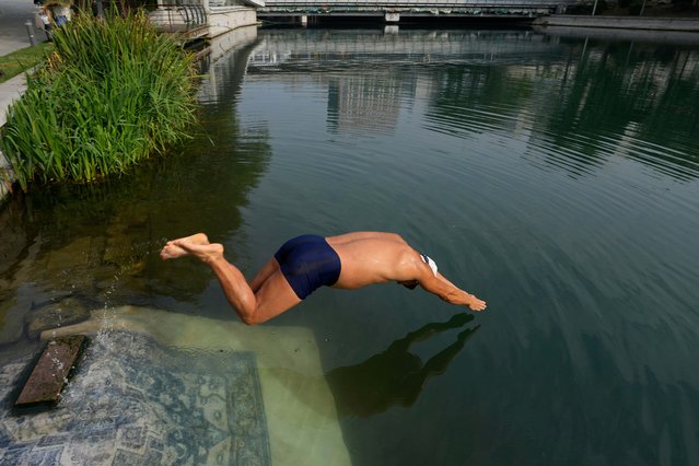 A man dive into the Liangma river in Beijing, China, Wednesday, October 15, 2025. (Photo by Ng Han Guan/AP Photo)