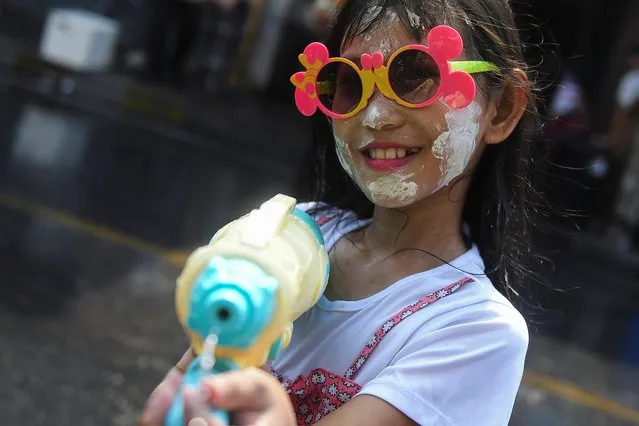 A girl plays with water as she celebrates the Songkran holiday which marks the Thai New Year in Bangkok, Thailand on April 13, 2023. (Photo by Chalinee Thirasupa/Reuters)