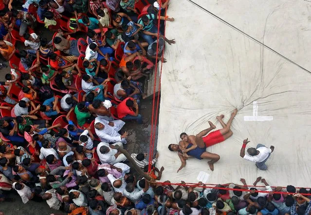 Wrestlers fight during an amateur wrestling match inside a makeshift ring installed on a road organised by local residents as part of the celebrations for the annual Hindu festival of Diwali in Kolkata, India, October 27, 2016. (Photo by Rupak De Chowdhuri/Reuters)