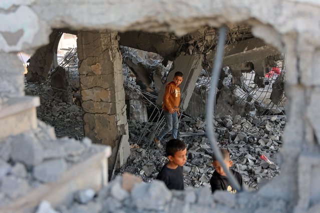 Palestinian boys walk amid the debris of a damaged building belonging to the Ministry of Religious Endowments, which was sheltering displaced people in the Zeitoun neighborhood of Gaza City on November 20, 2025, a day after it was targeted by Israeli army. Israeli air strikes on Gaza killed 27 people on November 19, officials in the Strip said, with Israel and Hamas each accusing the other of violating the fragile ceasefire in the Palestinian territory. (Photo by Omar Al-Qattaa/AFP Photo)