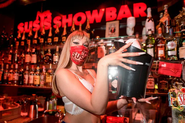 Lea, dancer in “Susis Show Bar” on St. Pauli, Hamburg, Germany serves drinks to guests with a face mask on June 19, 2020. After the lockdown by Corona, the entertainment on the Hamburg Kiez slowly starts again. (Photo by Axel Heimken/dpa)