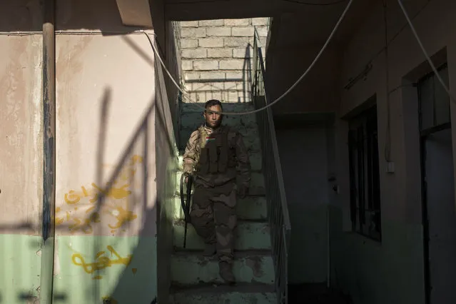 A Kurdish Peshmerga soldier walks inside a house that was used by the Islamic State in Faziliya, north of Mosul, Iraq, Wednesday, November 2, 2016. (Photo by Felipe Dana/AP Photo)
