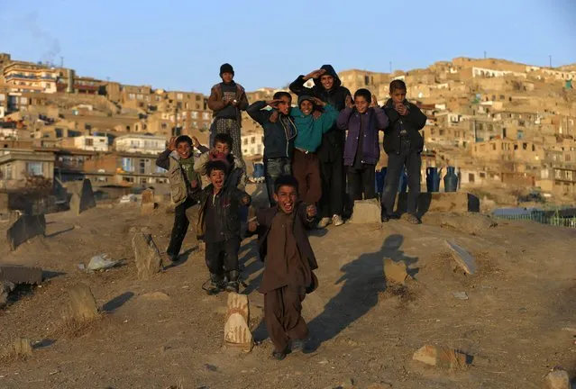 Boys who sell water react to the camera at a cemetery in Kabul January 14, 2015. (Photo by Mohammad Ismail/Reuters)