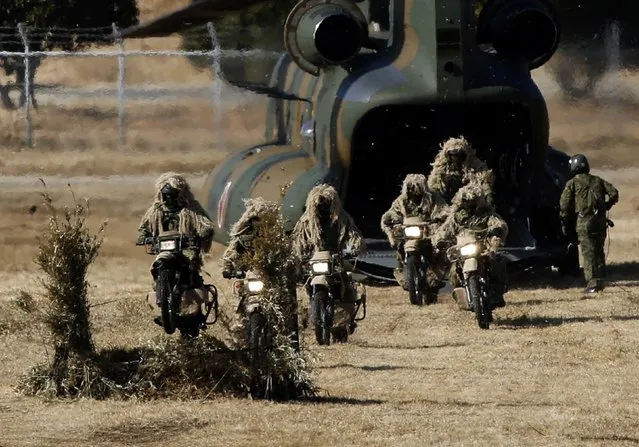 Members of the Japan's Ground Self-Defense Force 1st Airborne Brigade riding on bicycles get off from a CH-47 JA Cargo Helicopter during an annual new year military exercise at Narashino exercise field in Funabashi, east of Tokyo January 11, 2015. (Photo by Yuya Shino/Reuters)