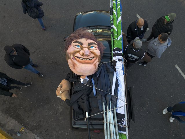 A large puppet in the likeness of Argentine President Javier Milei lays in the back of a truck after being paraded at a protest demanding work opportunities, from San Cayetano church to the Government House, in downtown Buenos Aires, Argentina, Wednesday, August 7, 2024, the feast day of St. Cajetan, known as the patron of the unemployed. (Photo by Rodrigo Abd/AP Photo)