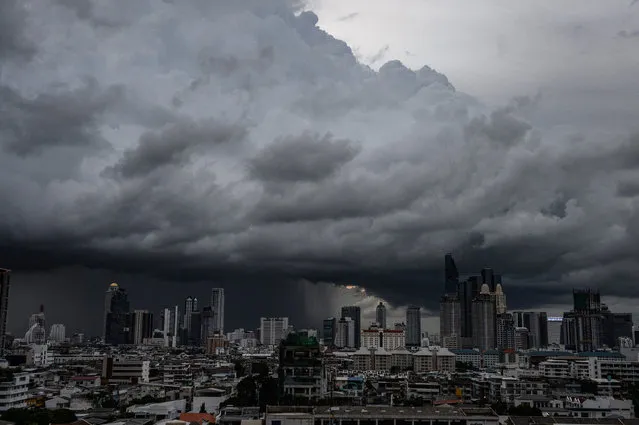 Heavy rain clouds move over the central business district in Bangkok on August 29, 2016. (Photo by Lillian Suwanrumpha/AFP Photo)