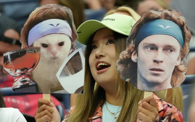 A fan of Russia's Andrey Rublev holds a cutout of him and a cutout of the Rublev cat meme during the men's singles round of 16 match between Rublev and Bulgaria's Grigor Dimitrov on day seven of the US Open tennis tournament at the USTA Billie Jean King National Tennis Center in New York City, on September 1, 2024. (Photo by Timothy A. Clary/AFP Photo)