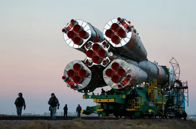 Policemen walk in front of the Soyuz MS-03 spacecraft for the next International Space Station (ISS) crew of Peggy Whitson of the U.S., Oleg Novitskiy of Russia and Thomas Pesquet of France as it is transported from an assembling hangar to the launchpad ahead of its upcoming launch, at the Baikonur cosmodrome in Kazakhstan, November 14, 2016. (Photo by Shamil Zhumatov/Reuters)