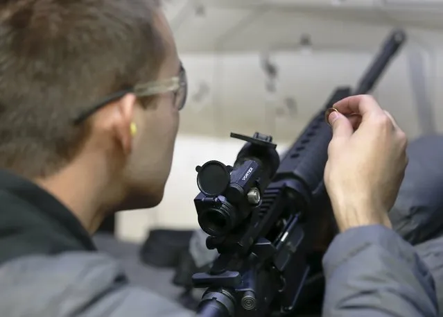 Alec Murrary adjusts the sights of an AR-15 assault rifle at the Ringmasters of Utah gun range, in Springville, Utah on December 18, 2015. (Photo by George Frey/Reuters)