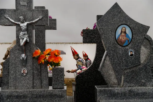 In this February 2, 2015 picture, members of the Endiablada brotherhood walk trough the cemetery after paying respect to their deceased fellow believers and relatives during the “Endiablada” traditional festival in Almonacid Del Marquesado, Spain. (Photo by Daniel Ochoa de Olza/AP Photo)