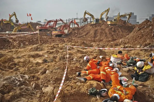Rescuers rest on mud as excavators dig through the debris to search for survivors at the site of a landslide which hit an industrial park on Sunday, in Shenzhen, Guangdong province, China, December 22, 2015. (Photo by Reuters/Stringer)