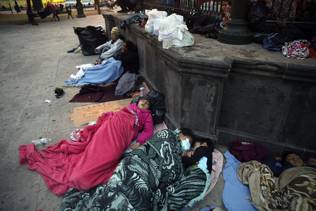 Migrants sleep under a gazebo at a park in the Mexican border city of Reynosa, Saturday, March 27, 2021. Dozens of migrants who earlier tried to cross into the U.S. in order to seek asylum have turned this park into an encampment for those expelled from the U.S. under pandemic-related presidential authority. (Photo by Dario Lopez-Mills/AP Photo)