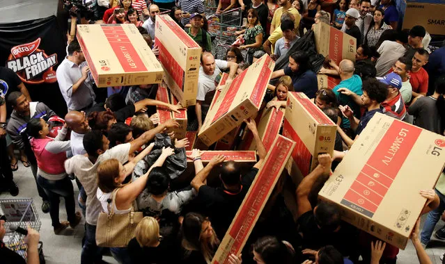Shoppers reach for television sets as they compete to purchase retail items on Black Friday at a store in Sao Paulo, Brazil, November 24, 2016. (Photo by Nacho Doce/Reuters)