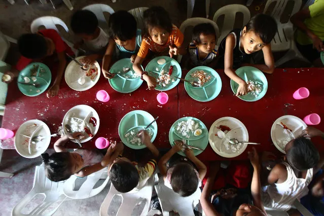 Children eat during a non-government organization's feeding program at a slum area in Manila, the Philippines on January 5, 2015. The country's population is expected to hit 104 million in 2016 with some 2 million infants expected to be born this year, according to the Philippine Commission on Population (PopCom). (Photo by Rouelle Umali/Xinhua via ZUMA Wire)