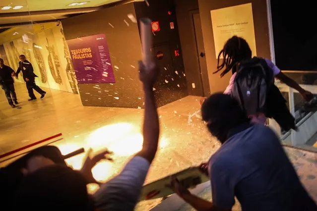 Demonstrators fire flares as they try to enter the State's Industries Federation of Sao Paulo building during protest against Brazilian President Michel Temer in Sao Paulo, in Brazil, 13 December 2016. (Photo by Fernando Bizerra Jr./EPA)