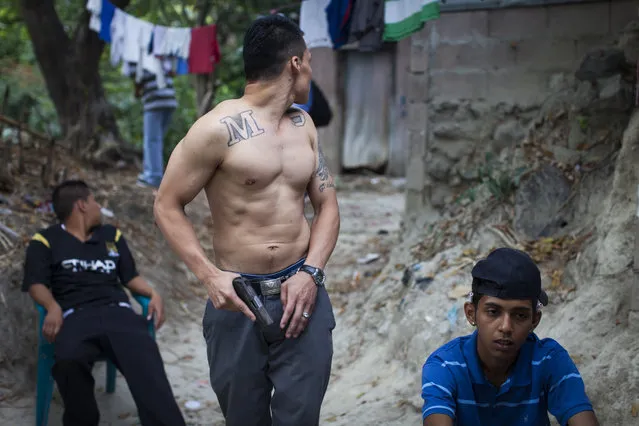 Mara Salvatrucha (MS) gang members show off their weapons in the Las Victorias district of San Salvador. (Photo by Adam Hinton)