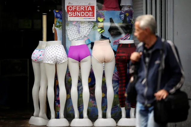 A man watches a store's showcase displaying a discount sign in Caracas, Venezuela, December 8, 2016. (Photo by Ueslei Marcelino/Reuters)