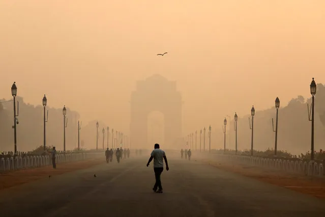 A man walks in front of the India Gate shrouded in smog in New Delhi, India, October 29, 2018. (Photo by Anushree Fadnavis/Reuters)