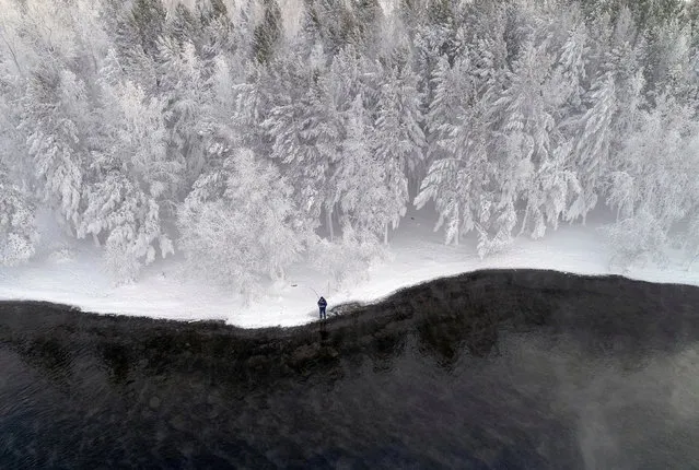 A man fishes on a bank of the Yenisei River covered with snow and hoarfrost with the air temperature at about –16 degrees Celsius outside the Siberian city of Krasnoyarsk, Russia on December 10, 2018. (Photo by Ilya Naymushin/Reuters)