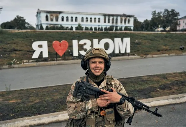 A Ukrainian soldier smiles in front of a city sign reading ''I Love Izium'' in Izium, Kharkiv region, Ukraine, Tuesday, September 14, 2022. Ukrainian troops piled pressure on retreating Russian forces pressing deeper into occupied territory and sending more Kremlin troops fleeing ahead of the counteroffensive that has inflicted a stunning blow on Moscow's military prestige. (Photo by Kostiantyn Liberov/AP Photo)