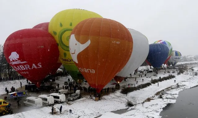 Hot air balloons wait to take off during the “Love Cup 2016” festival on Valentine's Day in Jekabpils, Latvia, February 14, 2016. Organisers said 50 couples in 27 hot air balloons participated in the event in an attempt to set a Guinness world record for the largest airborne wedding. (Photo by Ints Kalnins/Reuters)