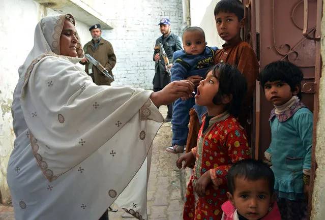 A Pakistani health worker administers polio drops to a child during a polio vaccination campaign in Quetta on February 15, 2016. Pakistan is one of only three countries in the world where polio remains endemic but years of efforts to stamp it out have been badly hit by reluctance from parents, opposition from militants and attacks on immunisation teams. (Photo by Banaras Khan/AFP Photo)