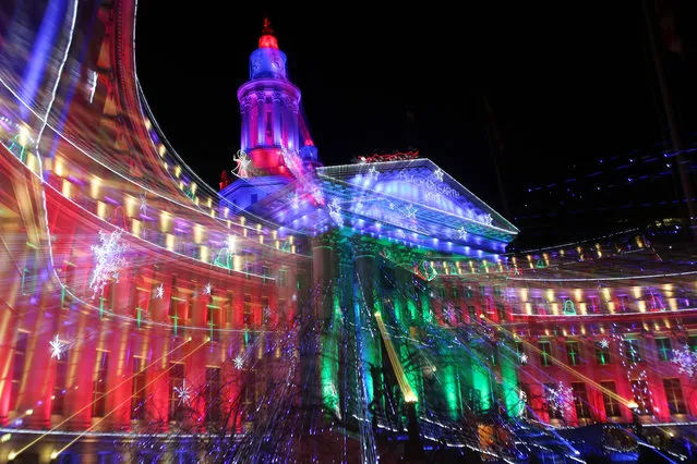 With the use of a zoom lens and a slow shutter speed, the holiday lights are blurred to create motion as they illuminate the Denver City/County Building in the annual display in downtown Denver late on Sunday, December 15, 2013. The lights will remain on through the holidays and then be turned back on in January to mark the run of the National Western Stock Show and Rodeo, which is one of the largest livestock exhibitions staged in North America. (Photo by David Zalubowski/AP Photo)