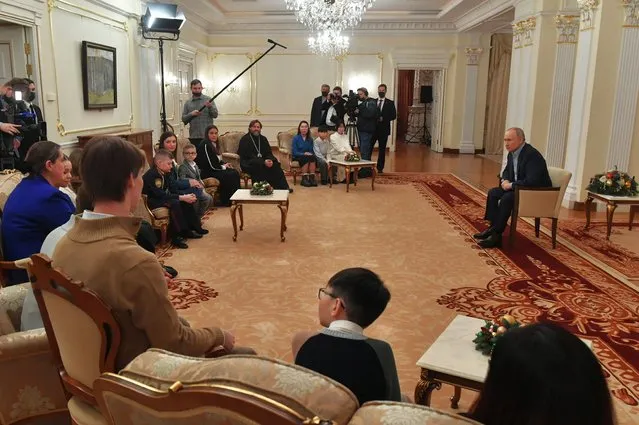 In this pool photograph distributed by Russian state agency Sputnik, Russia's President Vladimir Putin (R) attends a meeting with relatives of Russian soldiers, killed during the so-called “special military operation” in Ukraine, at the Novo-Ogaryovo state residence outside Moscow on January 7, 2024. (Photo by Mikhail Voskresenskiy/Pool via AFP Photo)