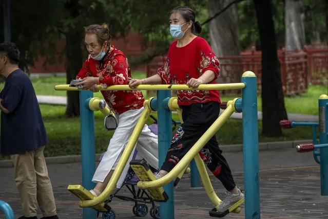 A woman wearing a face mask to protect against COVID-19 uses an exercise machine at a public park in Beijing, Thursday, September 9, 2021. (Photo by Mark Schiefelbein/AP Photo)