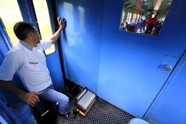 A Colombian musician rests as he travels on a “La Sabana” tourist train in Cajica March 1, 2015. (Photo by Jose Miguel Gomez/Reuters)