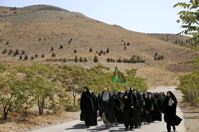 In this Thursday, August 22, 2013 photo, female members of the Basij paramilitary militia march during training session in Tehran, Iran. (Photo by Ebrahim Noroozi/AP Photo)