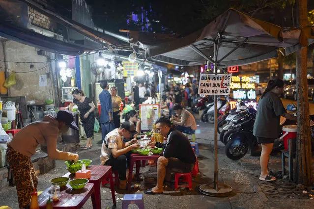 People dine on a sidewalk in Ho Chi Minh City, Vietnam, Thursday, January 11, 2024. (Photo by Jae C. Hong/AP Photo)