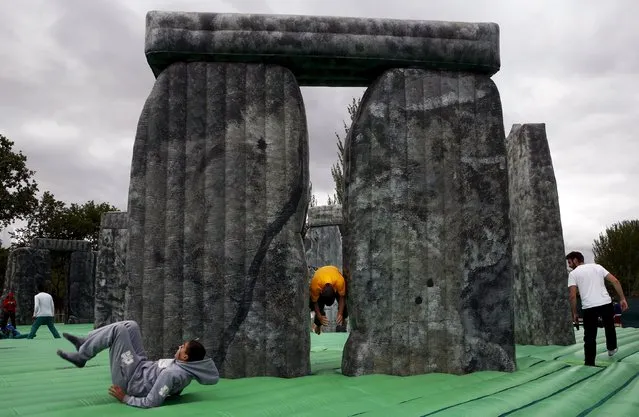 A man jumps through an inflatable replica of Stonehenge at a public park in Mostoles, Spain, April 27, 2015. (Photo by Susana Vera/Reuters)