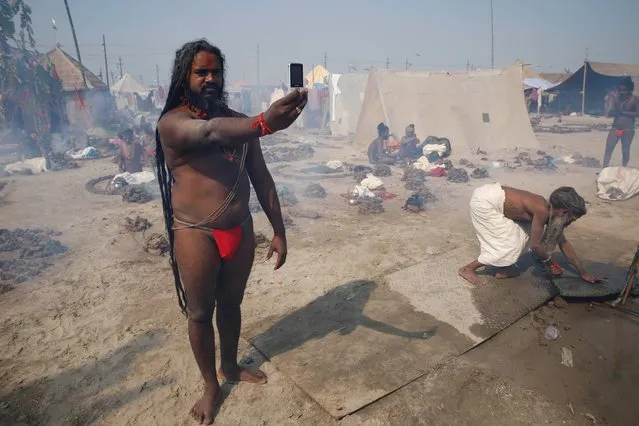 A Hindu holy man photographs himself on a mobile phone at Sangam, the confluence of rivers the Ganges and Yamuna at the annual traditional fair “Magh Mela” in Allahabad, India, Tuesday, February 4, 2014. Hundreds of thousands of devout Hindus bathe at the confluence during this astronomically auspicious period of over 45 days. (Photo by Rajesh Kumar Singh/AP Photo)