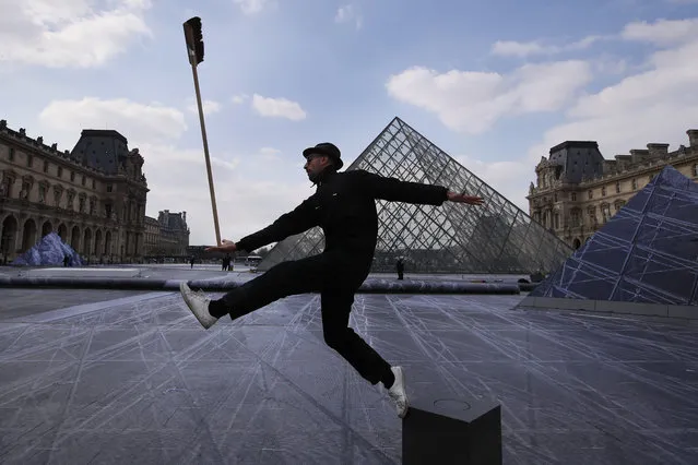 French street artist JR poses in the courtyard of the Louvre Museum near the glass pyramid designed by architect Leoh Ming Pei, in Paris, Wednesday, March 27, 2019 as the Louvre Museum celebrates the 30th anniversary of its glass pyramid. JR project is a giant collage of the pyramid to bring it out of the ground by revealing the foundations of the Napoleon courtyard where it is erected. (Photo by Francois Mori/AP Photo)
