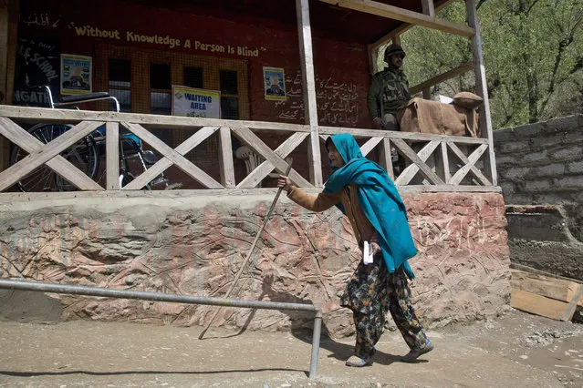 An elderly Kashmiri women walks toward a polling station to cast her vote during the second phase of India's general elections, in Baba Nagri, about 44 kilometers (28 miles) northeast of Srinagar, Indian controlled Kashmir, Thursday, April 18, 2019. Kashmiri separatist leaders who challenge India's sovereignty over the disputed region have called for a boycott of the vote. Most polling stations in Srinagar and Budgam areas of Kashmir looked deserted in the morning with more armed police, paramilitary soldiers and election staff present than voters. (Photo by Dar Yasin/AP Photo)