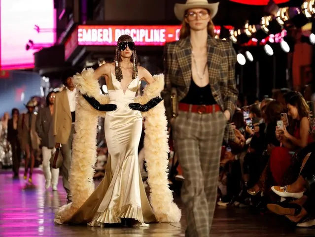 Models walk on the sidewalk of Hollywood Blvd during the Gucci Love Parade fashion show in Los Angeles, California, U.S., November 2, 2021. (Photo by Mario Anzuoni/Reuters)