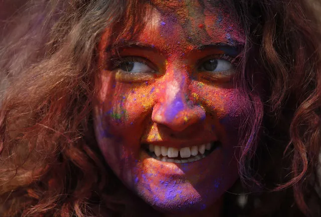 A woman with coloured powder smeared on her face smiles as she celebrates Holi, the Festival of Colours, in Kathmandu, Nepal, March 22, 2016. (Photo by Navesh Chitrakar/Reuters)