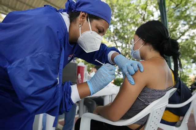 A Venezuelan woman, who lives in Cucuta, receives a dose of the AstraZeneca COVID-19 vaccine, in Villa Del Rosario, Colombia, Friday, November 12, 2021. (Photo by Fernando Vergara/AP Photo)