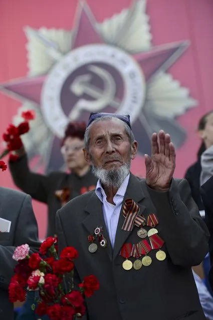 A World War Two veteran waves during the Immortal Regiment march on the Red Square as part of the Victory Day celebrations in Moscow, Russia, May 9, 2015. (Photo by Reuters/Host Photo Agency/RIA Novosti)