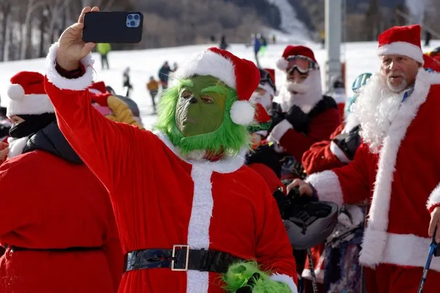 A skier dressed as the Grinch takes a selfie before taking part in the charity Santa Sunday at Sunday River ski resort in Bethel, Maine, U.S., December 5, 2021. (Photo by Brian Snyder/Reuters)