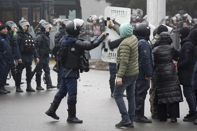 A demonstrator gives back a shield to a riot police officer during a protest in Almaty, Kazakhstan, Wednesday, January 5, 2022. (Photo by Vladimir Tretyakov/AP Photo)